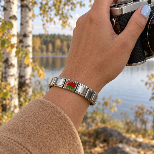 Belarus flag Italian charm on a polished silver charm bracelet beside an autumn birch forest lake