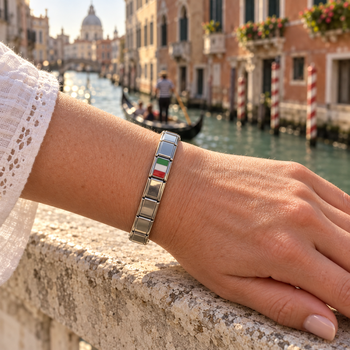 Italy flag Italian charm on a polished silver standard Italian charm bracelet beside a sunlit Venetian canal