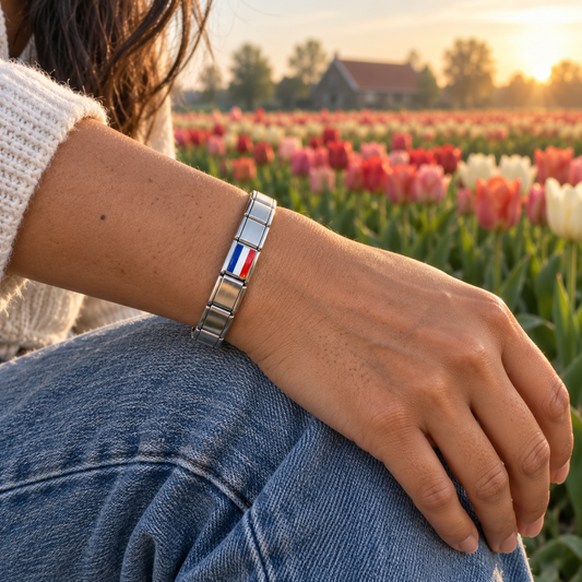 Netherlands flag charm on a polished silver charm bracelet beside colorful Dutch tulip fields