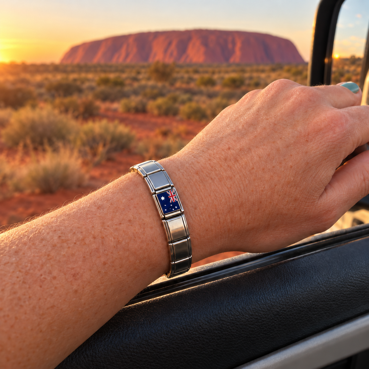 Australia flag Italian charm on a polished silver charm bracelet at Uluru in the Australian outback
