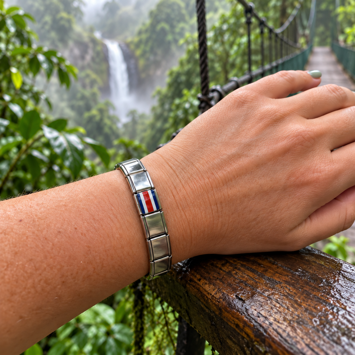 Costa Rica flag Italian charm on a polished silver bracelet overlooking a rainforest waterfall