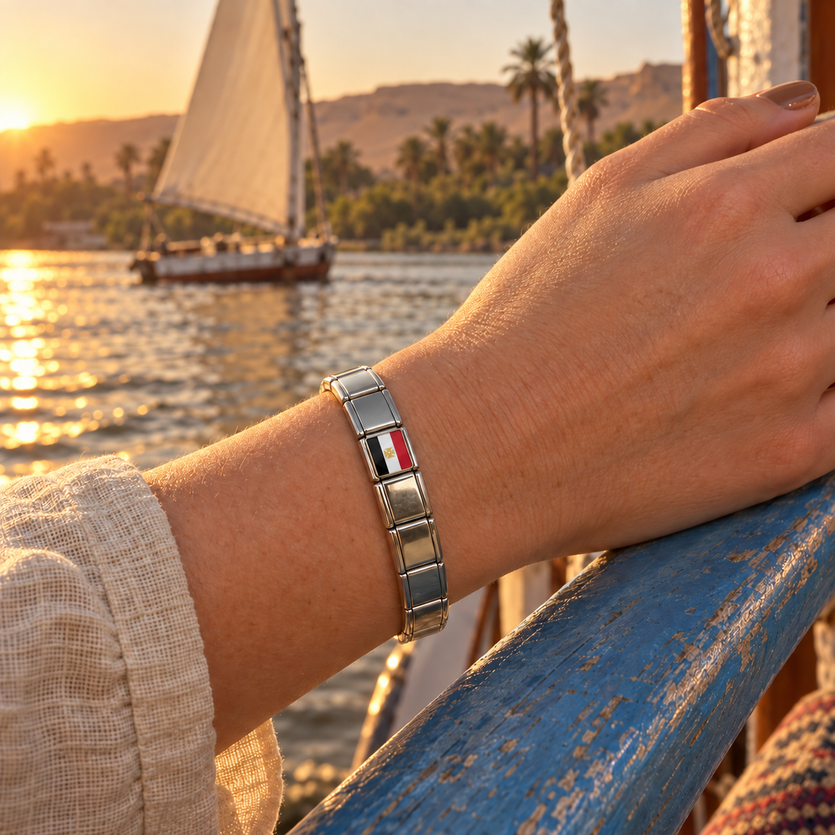 Egypt flag Italian charm on a polished silver Italian charm bracelet aboard a Nile felucca at sunset
