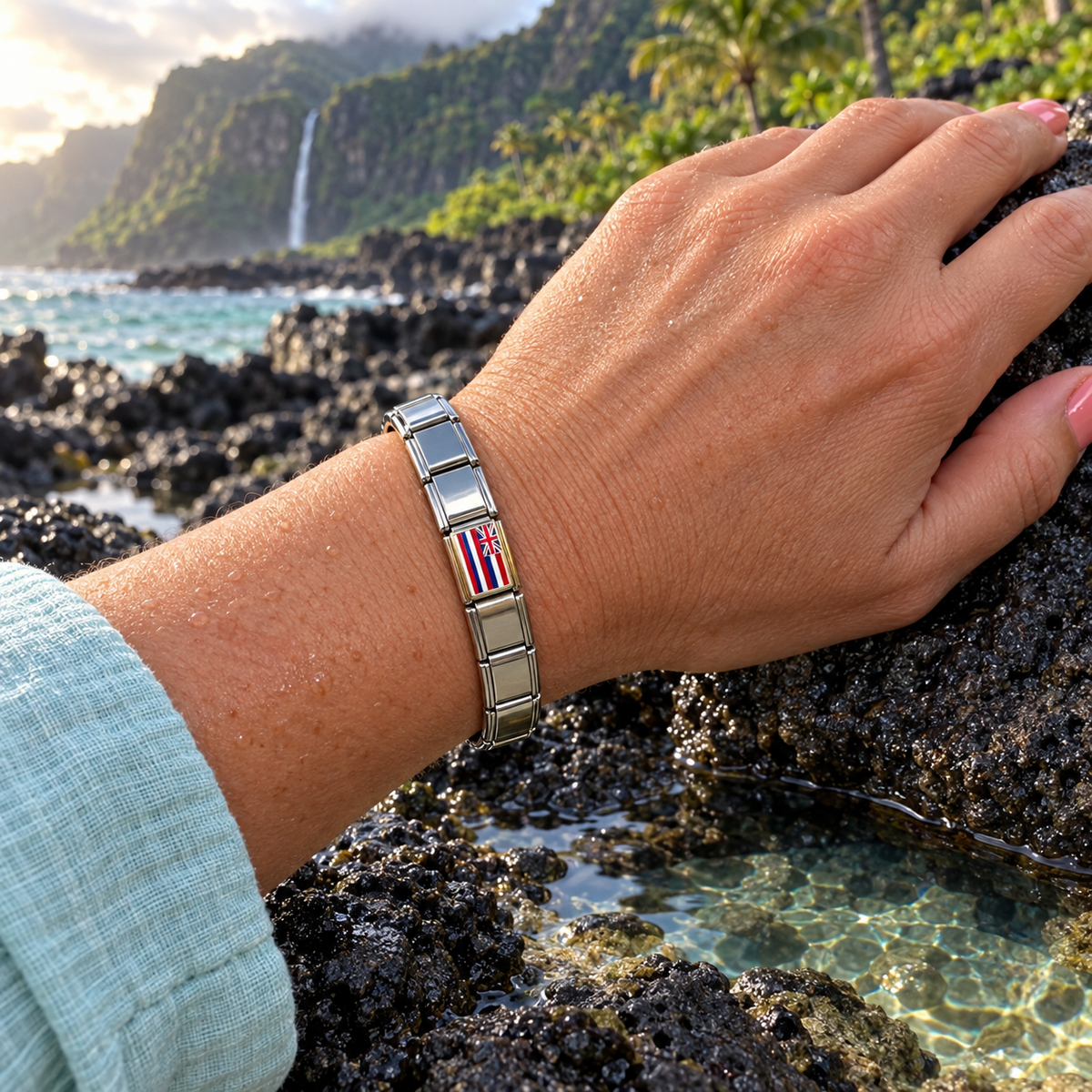 Hawaii flag Italian charm on a polished silver base italian charm bracelet worn beside a tropical volcanic tide pool