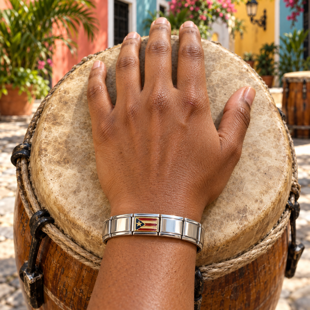 Puerto Rico flag Italian charm on a shiny silver bracelet worn by a woman resting her hand on a bomba drum in Old San Juan