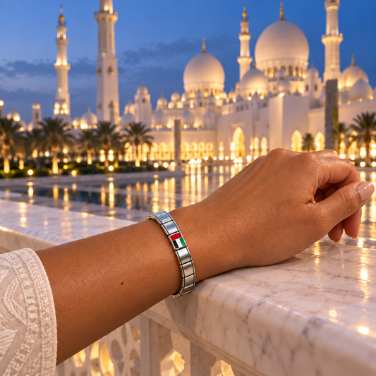 UAE flag Italian charm on a silver bracelet overlooking the Sheikh Zayed Grand Mosque at twilight